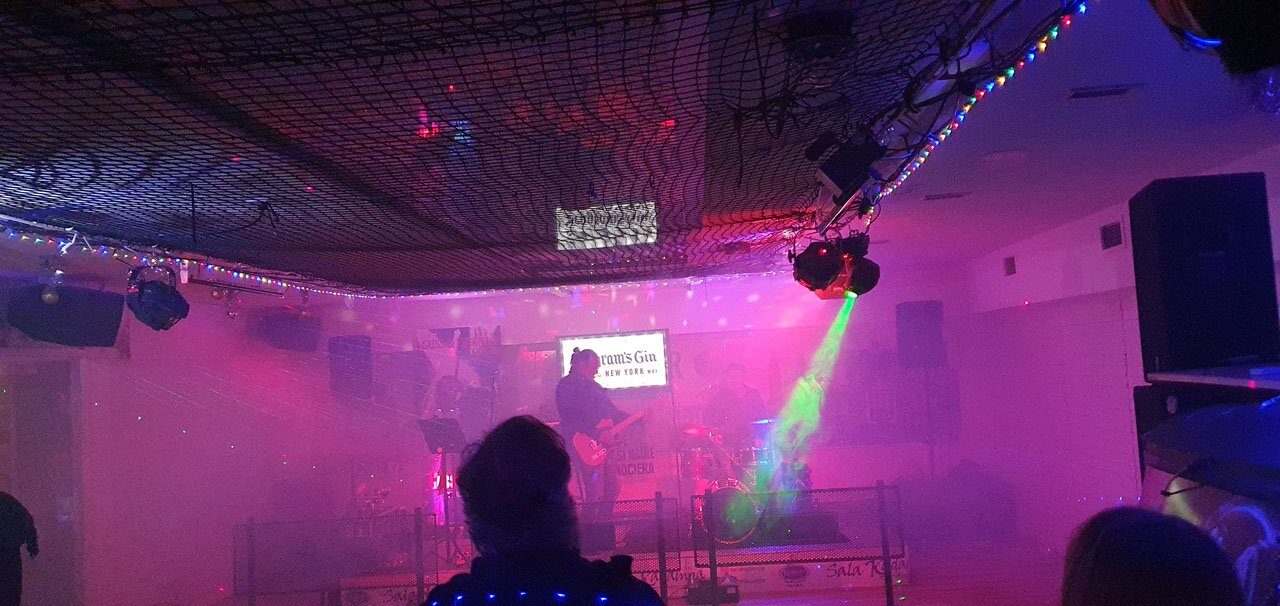 Un concierto en la planta de abajo, con el público y las luces magenta