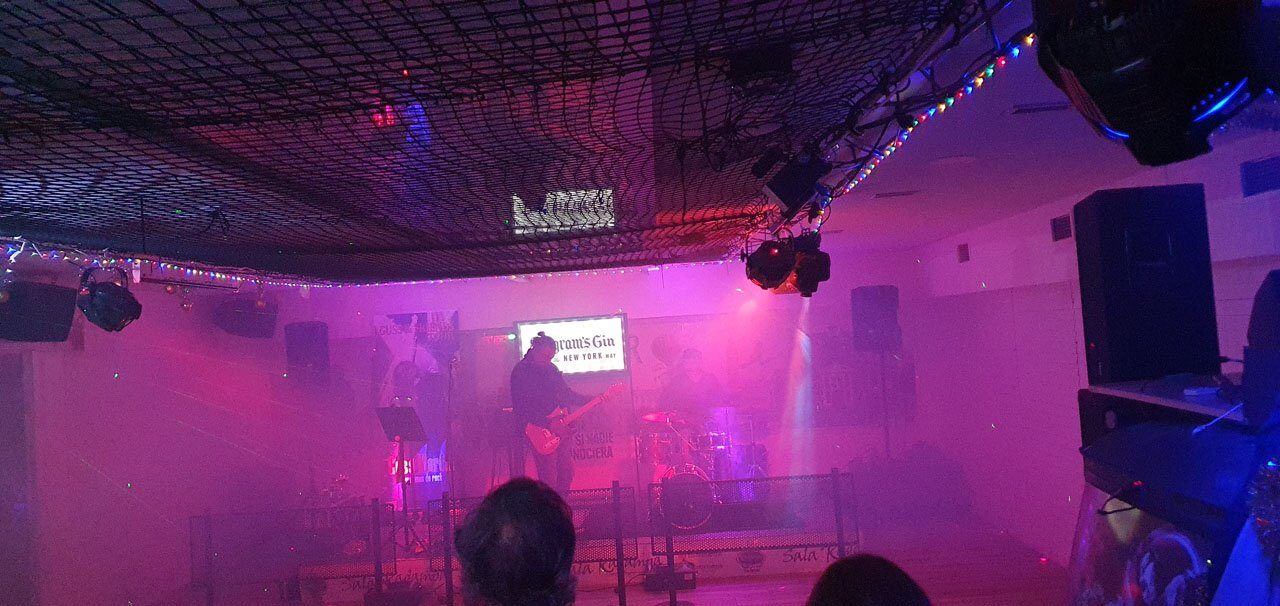 Los focos de la sala tiñendo de magenta el escenario durante un directo