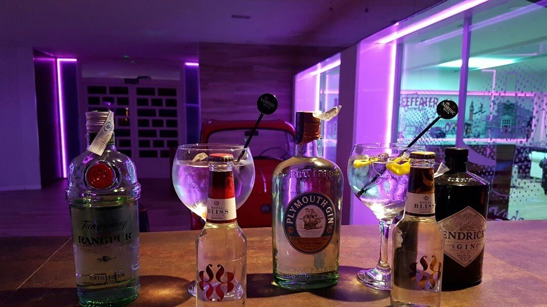 Copas y botellas de ginebra preparadas sobre la barra