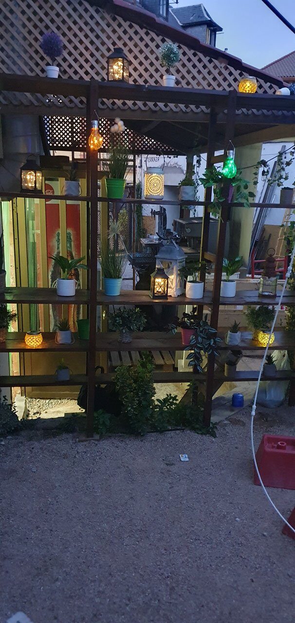 Estantería de la terraza con plantas, farolillos y macetas